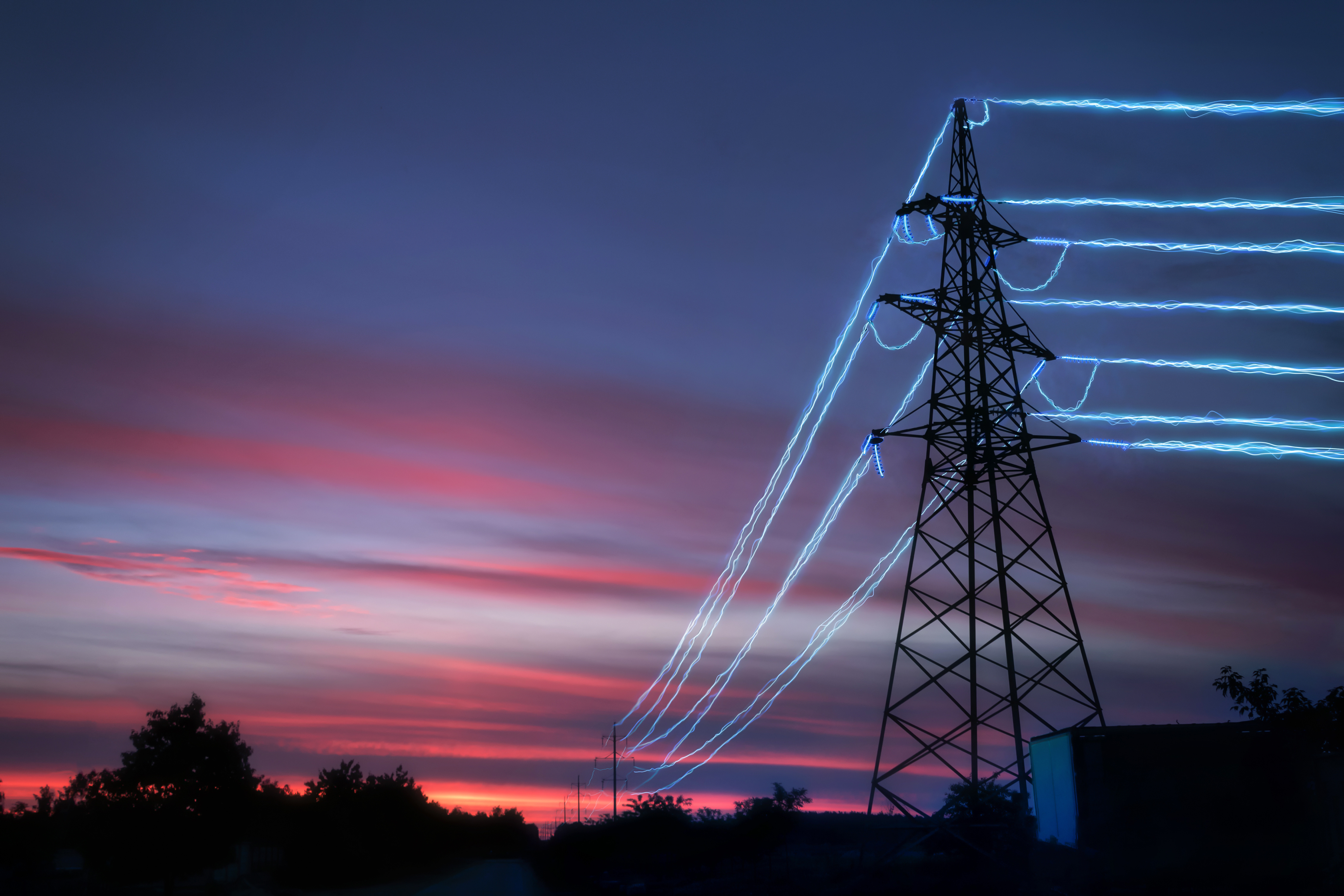 Electricity pylon illuminated at night. Credit: Adobe Stock / Артур Ничипоренко