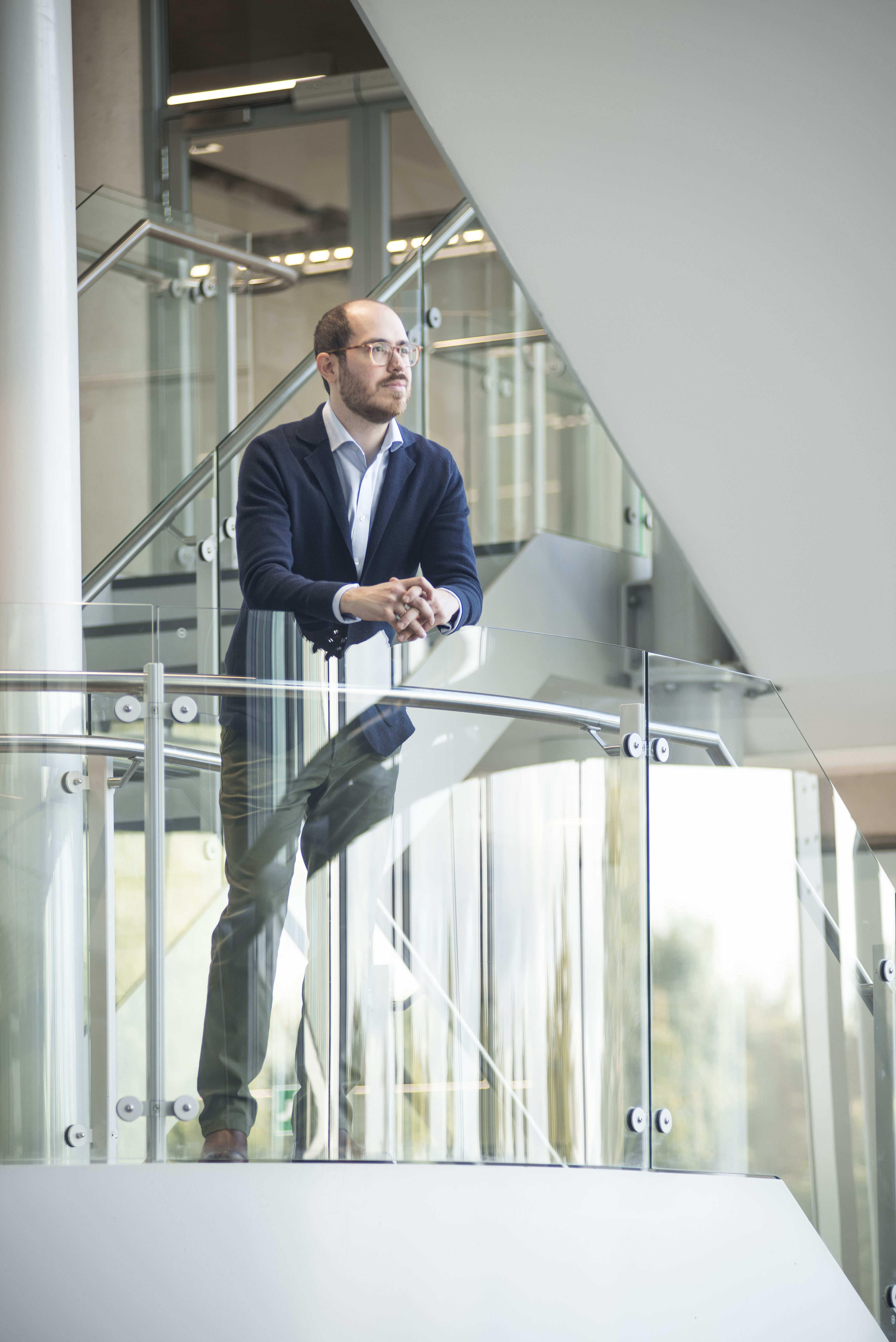 A photo of Dr Giannikas standing on a staircase in the School of Management