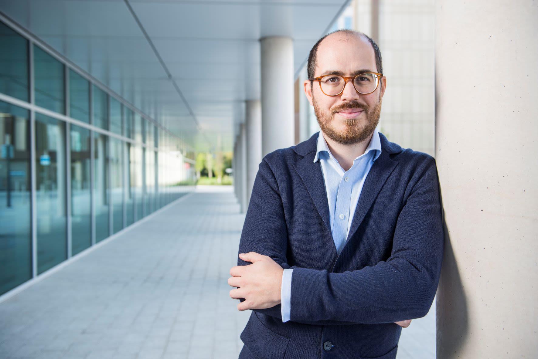 A photo of Dr Vaggelis Giannikas leaning against the columns outside the School of Management building