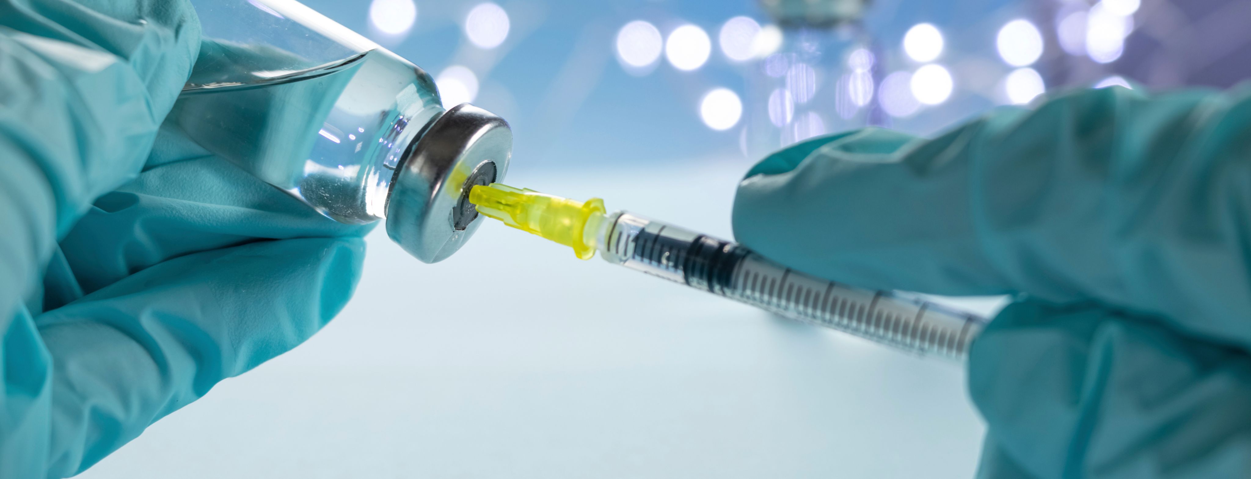 Needle taking fluid from a vial